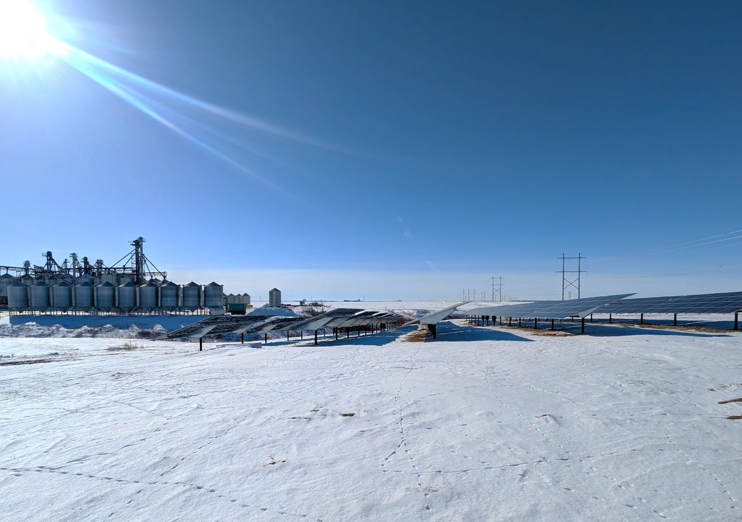 A large solar system built on a farmers land. A seed cleaning plant stands in behind